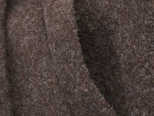 Gros plan sur la texture du manteau en cachemire marron foncé montrant les fibres de laine