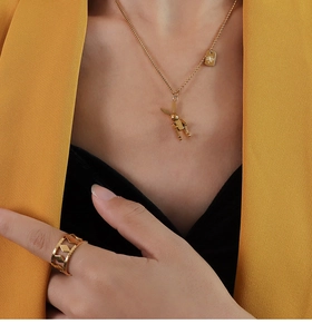Dettaglio della collana con coniglio meccanico dorato e dell'anello geometrico cavo