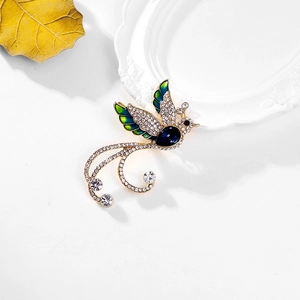 Luxurious phoenix brooch with blue enamel wings and deep blue teardrop crystal inlay