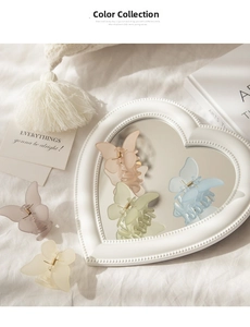 Close-up of butterfly hair clips in various matte Morandi colors on a heart mirror