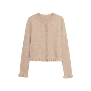 Close-up of oatmeal knit cardigan with ruffled cuffs and classic button-down front detailing