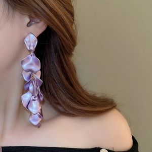 Close-up of purple petal tassel long earrings with layered leaf design on model