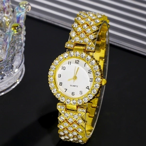Detailed macro of a gold quartz watch with rhinestones next to a crystal crown