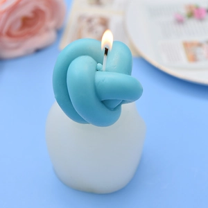 Artistic sky blue knot scented candle with white base in a modern home decor setting