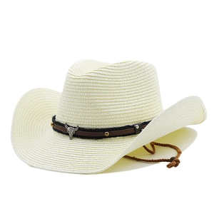 Detail of straw cowboy hat featuring bull head metal emblem and adjustable chin strap