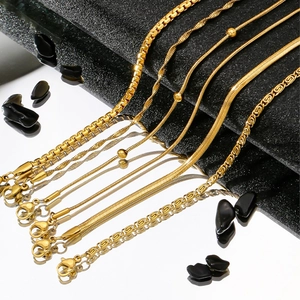 Detail shot of 5 assorted gold stainless steel chains over a reflective mirror