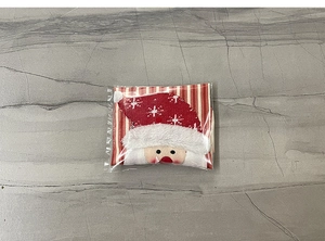 Detail view of red and white striped Christmas wine bottle cover with 3D Santa ornament