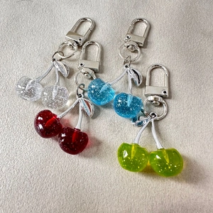 Sparkling 3D cherry fruit keychains in clear, red, blue, and green glitter resin