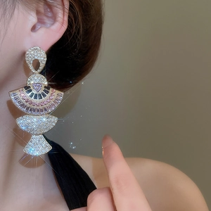 Close-up of fan-shaped crystal earrings with colorful rhinestones on a model