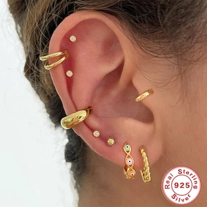 S925 sterling silver evil eye enamel hoops and gold earring set worn by a model