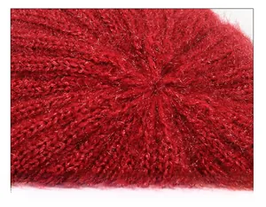Detail of red knit hat crown showing precise radial stitching and soft texture