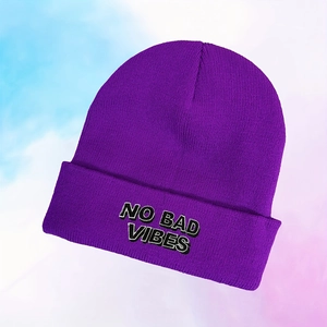 Gros plan détaillé de la broderie NO BAD VIBES sur un bonnet en tricot violet
