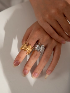 Detailed macro view of asymmetric lava texture rings in gold and silver finish