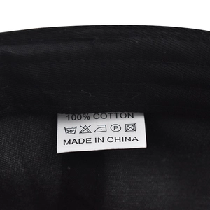 Detailed view of internal wash label showing 100% cotton material on a black baseball cap