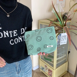 Mint green corduroy makeup bag with embroidered smiley faces and soft velvet texture