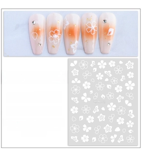 Detail of white flower nail stickers with gold foil accents and application guide