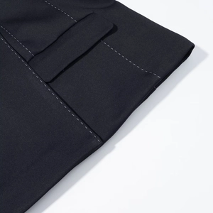 Dettaglio dell'orlo del blazer blu scuro con cuciture bianche a contrasto e tasca finta