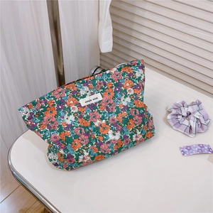 Detail of floral canvas makeup bag with orange and purple flowers and simple wish label