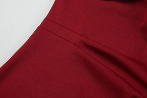 Close-up detail of burgundy evening dress showing fine fabric texture and neat stitching