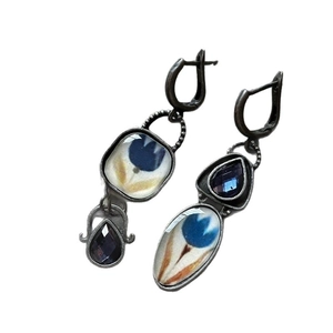 Vintage Egyptian style enamel flower earrings with purple teardrop crystals on white background