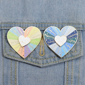 Dettaglio di spille rotanti in smalto a forma di cuore su una giacca di jeans blu