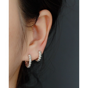 Minimalist silver hoop earrings with beaded texture on model, elegant retro style jewelry