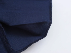 Close-up of deep blue satin fabric showing fine texture and meticulous stitching details
