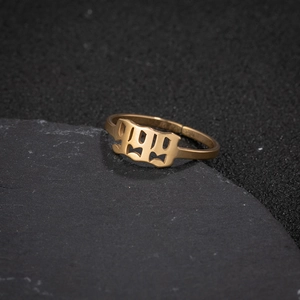 Macro shot of gold gothic 999 angel number ring on stone base with sharp metallic detail