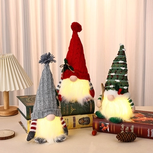 Detailansicht von drei leuchtenden Weihnachtswichteln mit Strickmützen in gemütlicher Form