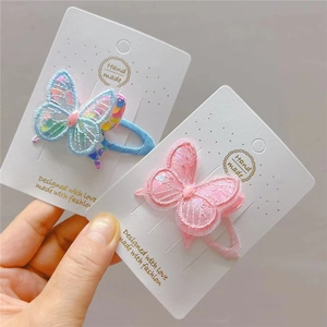 Detailed view of handmade lace butterfly hair clips with sequins and pink blue embroidery
