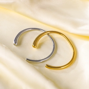 Minimalist C-shaped stainless steel bracelets in gold and silver finish on silk