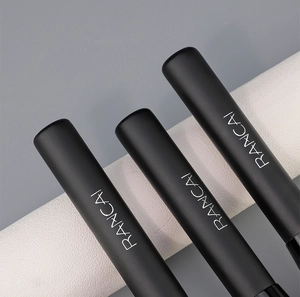 Gros plan de trois manches de pinceaux à fond de teint noir mat avec logo professionnel
