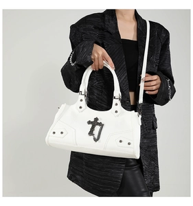 Detailansicht der weißen Punk-Handtasche mit Metallkreuzen und dekorativer Kette