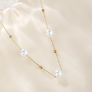 Close-up of elegant gold beads and white pearls on a stainless steel choker necklace