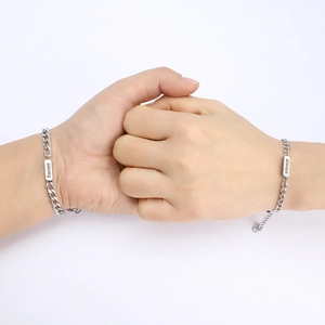 Close-up of silver stainless steel couple bracelets with Forever and Always engraving