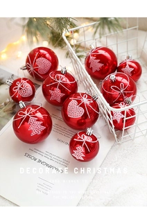 Detail of red Christmas baubles with white heart and star patterns in a white metal basket