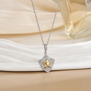 Two-tone shield pendant necklace with sparkling cubic zirconia and golden star center