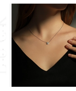 Gros plan du pendentif moissanite 0,8ct sur collier en argent s925 porté sur la clavicule