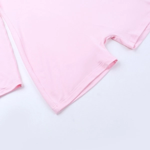 Vue détaillée des poignets et de l'ourlet en maille de coton rose clair de la combinaison