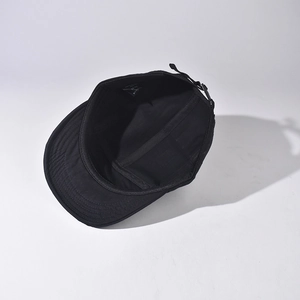Detail view of black cotton camper cap interior with adjustable strap and size label