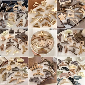 Macro detail of various minimalist matte and glossy hair claws in earth tones
