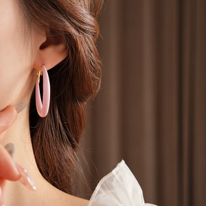 Close-up of pink drip oil hoop earrings worn by a model for a chic and sweet look