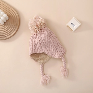 Detail of pink knitted baby hat with soft fleece lining and braided ear flaps