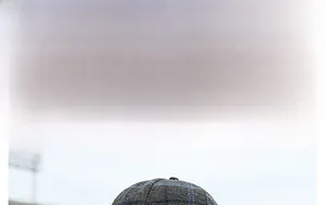 Detail showing the gray plaid wool texture and British vintage pattern of the baseball cap