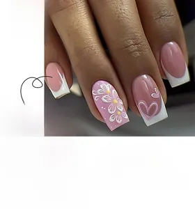 Detail of French white tip press-on nails with 3D floral accents and heart patterns