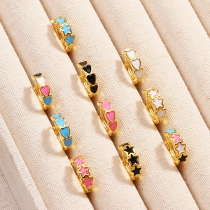 Golden enamel hoop earrings set with colorful heart and star patterns in jewelry box