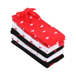 Close-up of heart pattern knit stockings with satin bow detail in red black and white