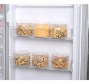 Set of 6 clear plastic food storage jars with white lids organized in a refrigerator door