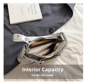 Detailed interior of a silver leather shoulder bag with phone and cosmetics inside