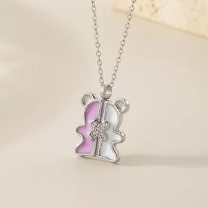 Detailed close-up of a pink and white enamel bear pendant necklace with crystal accents